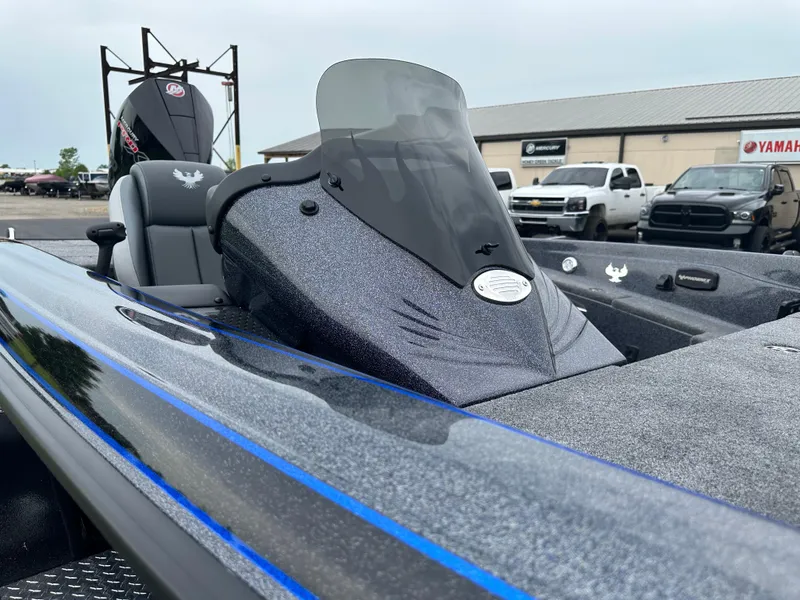 Slide: The Image of 2025 Phoenix 819 ZXL boat with sleek design and windshield, parked outdoors. - 12