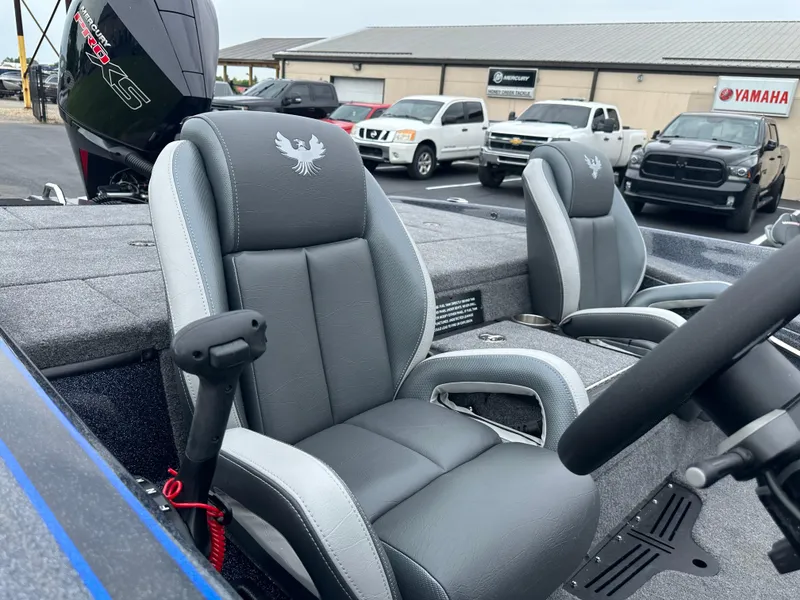 Slide: The Image of 2025 Phoenix 819 ZXL boat interior with gray seats and steering wheel, parked outdoors. - 13