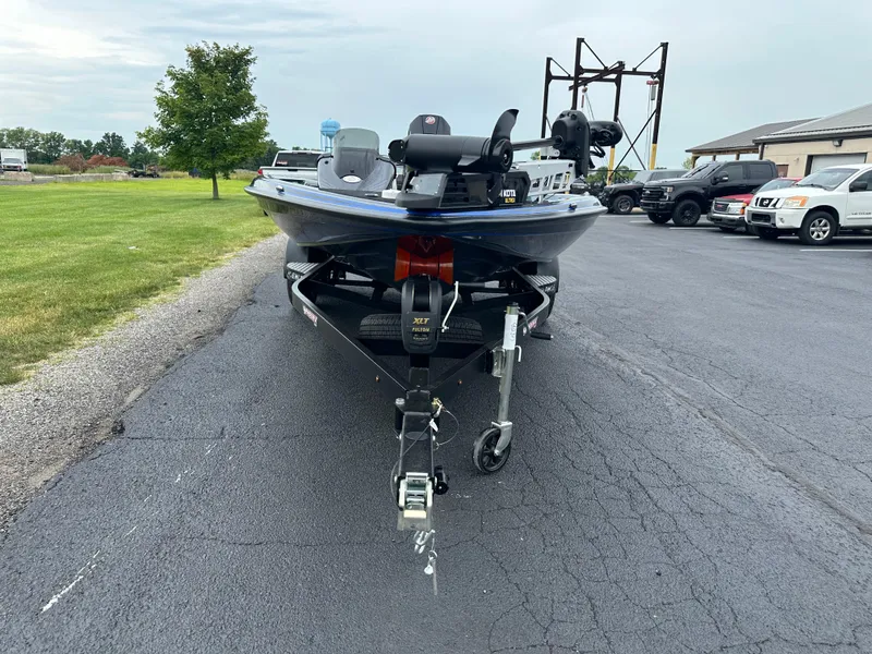 Slide: The Image of 2025 Phoenix 819 ZXL boat on trailer, parked on asphalt near grassy area and vehicles. - 3