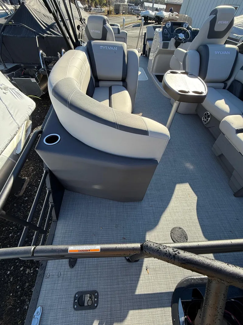 Slide: The Image of 2025 Sylvan L-3 LZ pontoon boat interior with plush seating and table. - 13