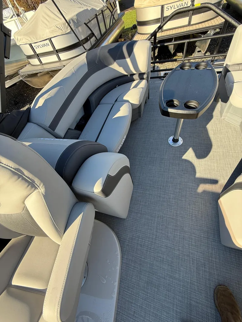 Slide: The Image of 2025 Sylvan L-3 LZ pontoon boat interior with plush seating and table. - 7