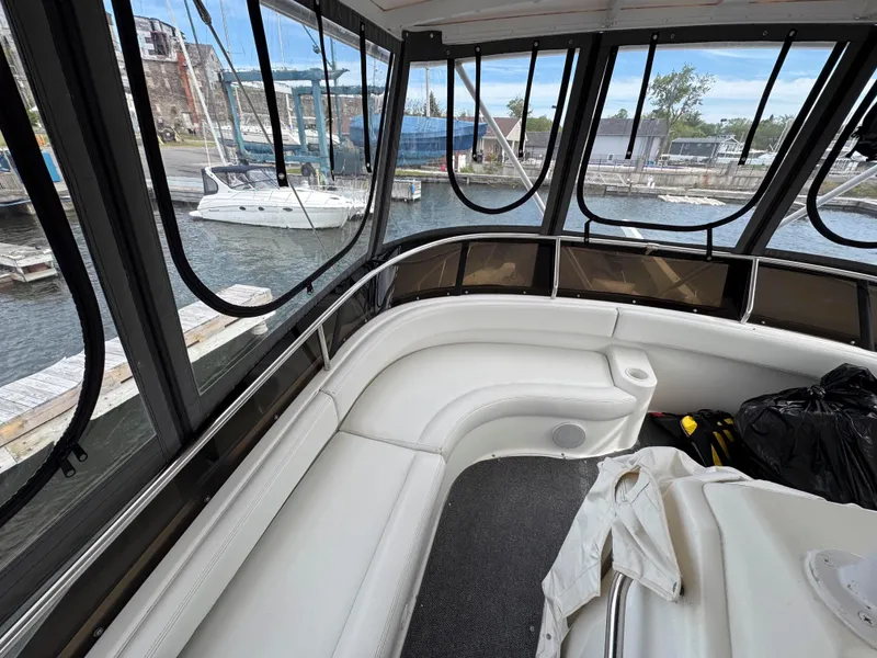 Slide: The Image of 1997 Silverton 41 Convertible boat interior with white seating and marina view. - 10