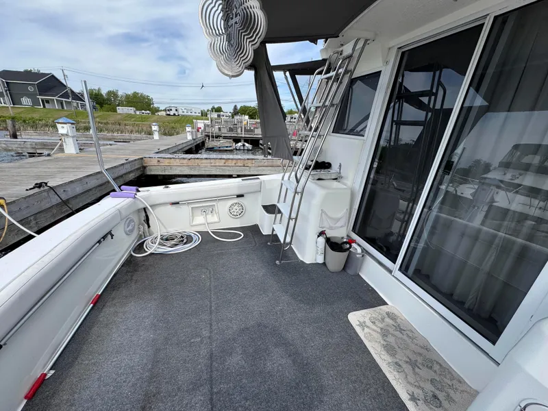 Slide: The Image of 1997 Silverton 41 Convertible boat deck with ladder and dock view. - 16
