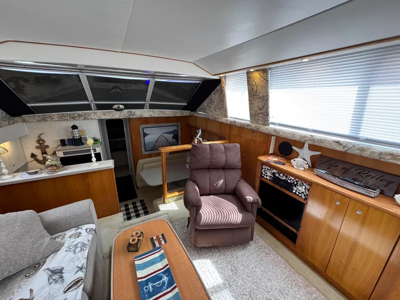 Slide: The Image of Interior of a 1997 Silverton 41 Convertible yacht with cozy seating and elegant decor. - 19