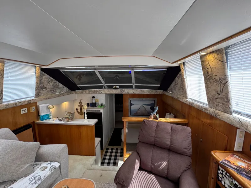 Slide: The Image of Interior of a 1997 Silverton 41 Convertible yacht with cozy seating and modern amenities. - 21
