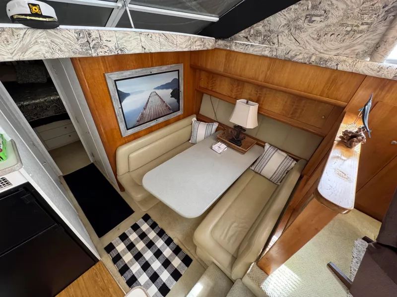 Slide: The Image of Interior of 1997 Silverton 41 Convertible yacht with cozy dining area and nautical decor. - 23