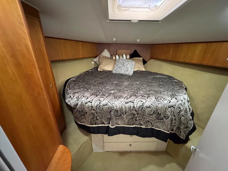 Slide: The Image of 1997 Silverton 41 Convertible cabin with elegant bedding and wood paneling. - 26