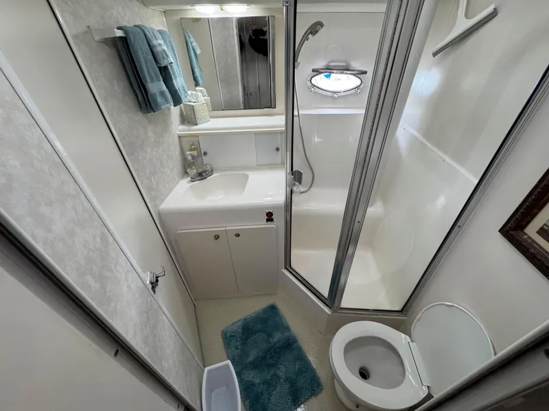 Slide: The Image of Bathroom interior of 1997 Silverton 41 Convertible yacht, featuring shower, sink, and toilet. - 28