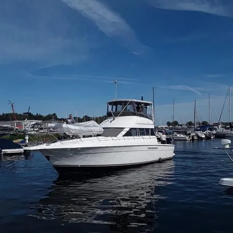 Slide: The Image of 1997 Silverton 41 Convertible yacht docked in a marina under a clear blue sky. - 3