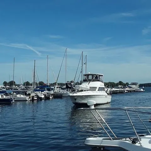 Slide: The Image of 1997 Silverton 41 Convertible yacht docked in a marina under clear blue skies. - 4