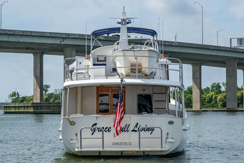 Slide: The Image of Kadey-Krogen 48 North Sea yacht, 2000 model, docked near a bridge with American flag. - 4