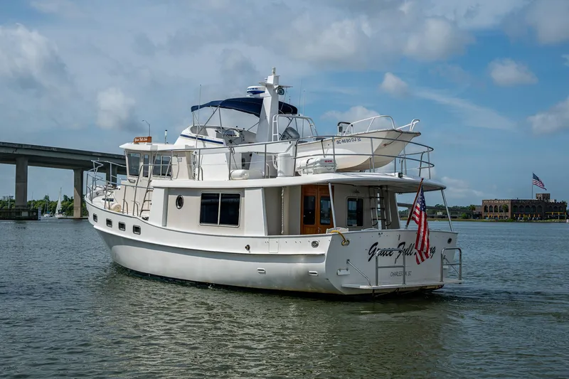 Slide: The Image of Kadey-Krogen 48 North Sea yacht, 2000 model, cruising on a calm river under a cloudy sky. - 5