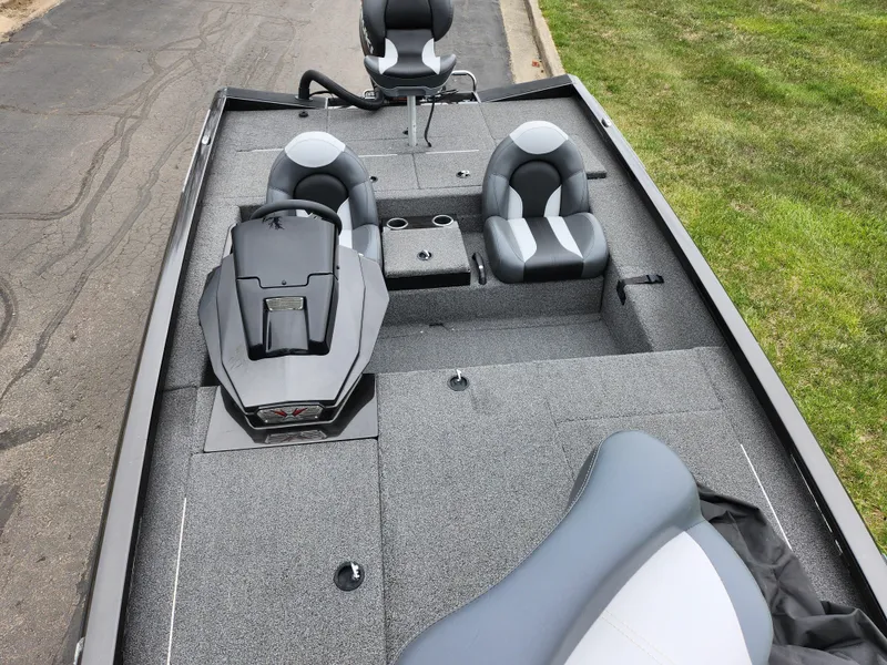 Slide: The Image of 2021 Vexus AVX189 boat interior with gray seating and console, parked on pavement. - 20