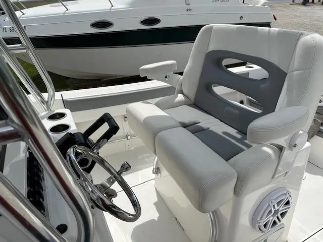 Slide: The Image of 2018 Release 232 RX Center Console boat with cushioned helm seat and steering wheel. - 15