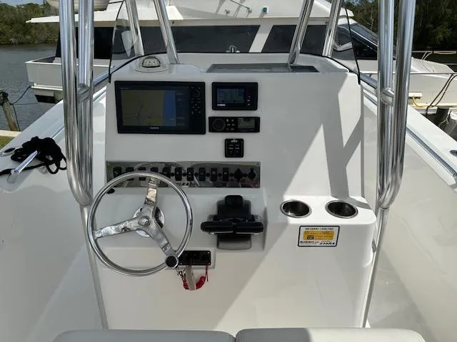 Slide: The Image of Center console of 2018 Release 232 RX boat with navigation equipment and steering wheel. - 17