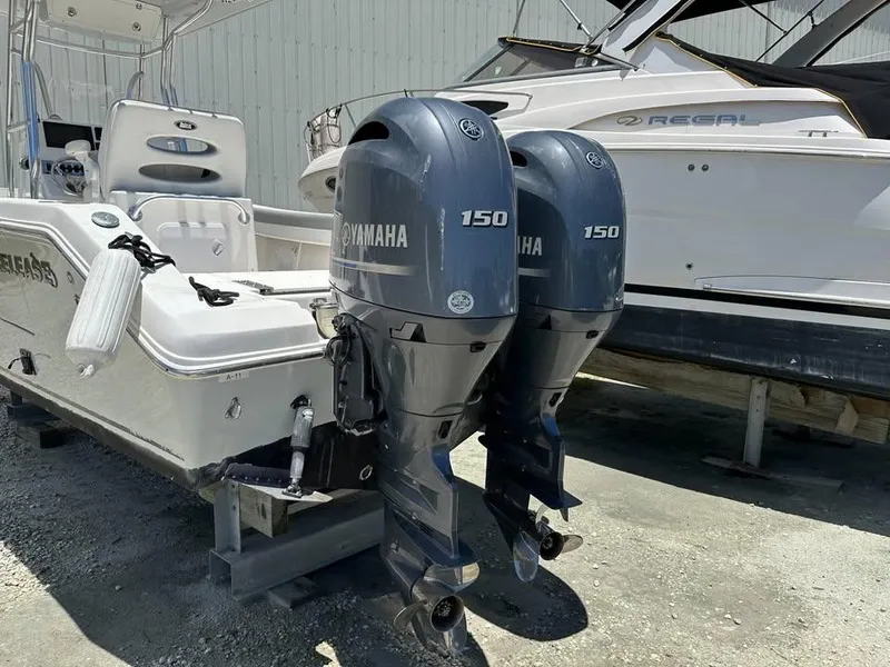 Slide: The Image of 2018 Release 232 RX Center Console with twin Yamaha 150 engines, docked beside another boat. - 2
