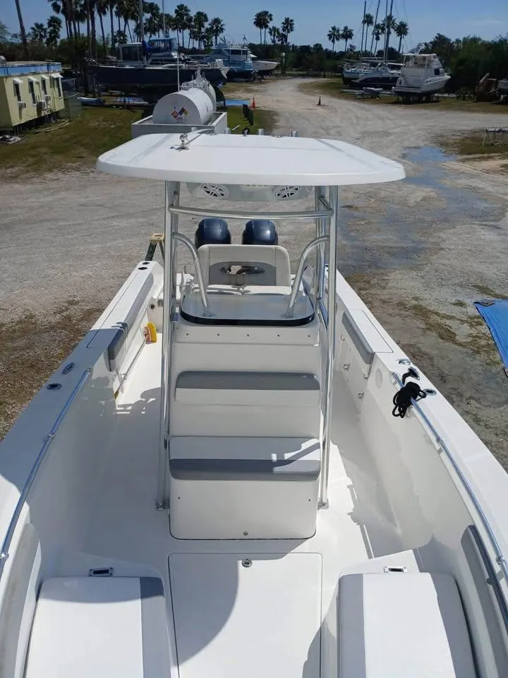 Slide: The Image of 2018 Release 232 RX Center Console boat with T-top, docked outdoors. - 7