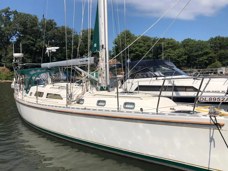 The Image of Sailboat docked in marina, Outbound 44 model, year 2000, with green sail cover. - 0