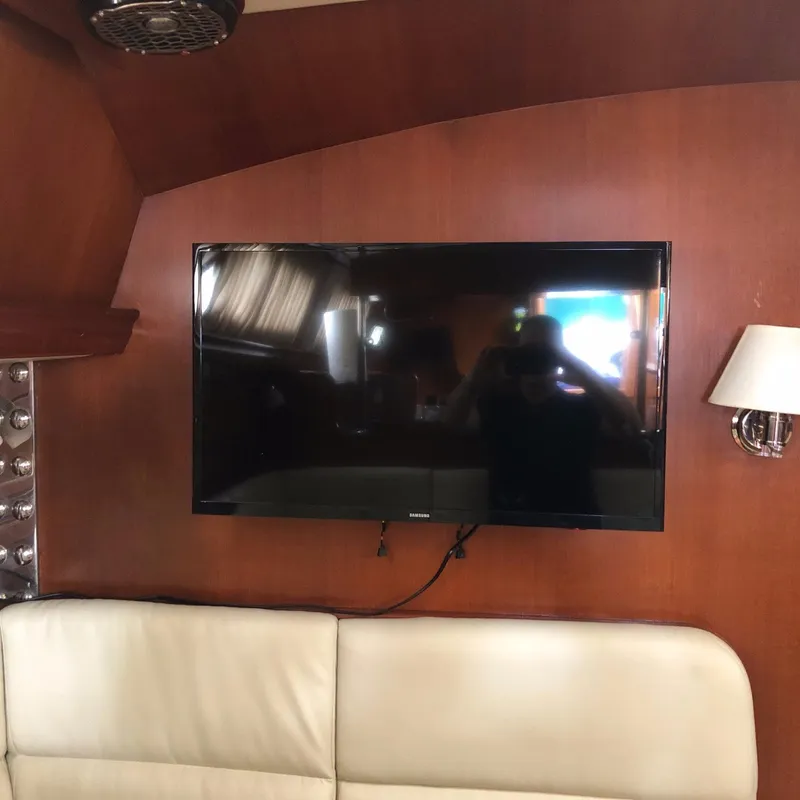 Slide: The Image of Flat-screen TV mounted on wooden wall inside 2000 Outbound 44 yacht cabin. - 14