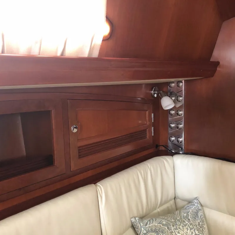 Slide: The Image of Interior of 2000 Outbound 44 yacht with wooden cabinetry and white cushioned seating. - 15
