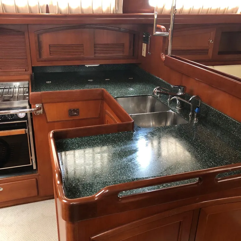 Slide: The Image of Luxurious wooden yacht kitchen with green countertops, dual sink, and stove, Outbound 44, 2000 model. - 4