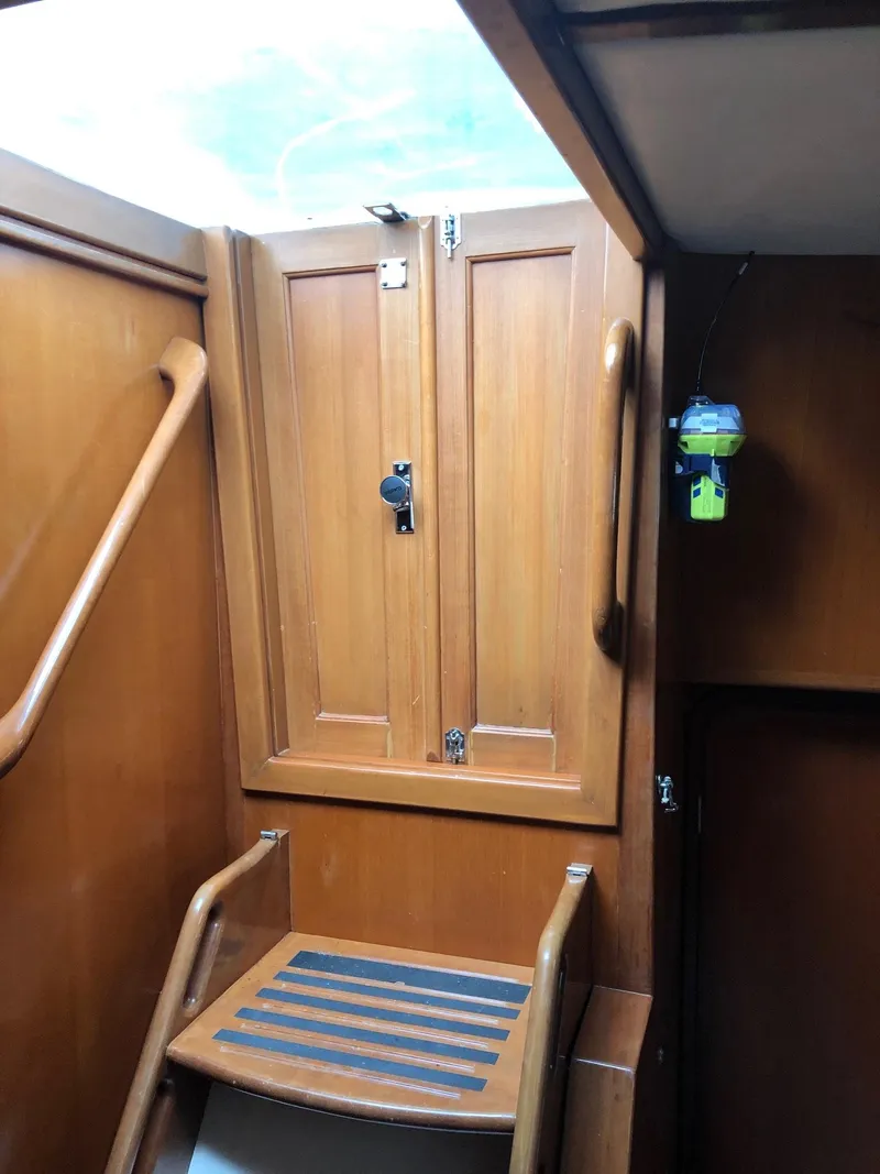 Slide: The Image of Wooden interior of 2000 Outbound 44 sailboat with steps and storage cabinet. - 48