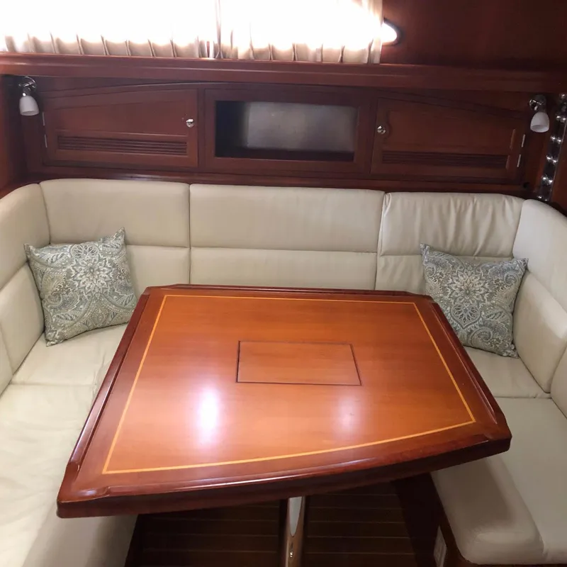 Slide: The Image of Luxurious interior of 2000 Outbound 44 yacht with elegant wood table and cushioned seating. - 8