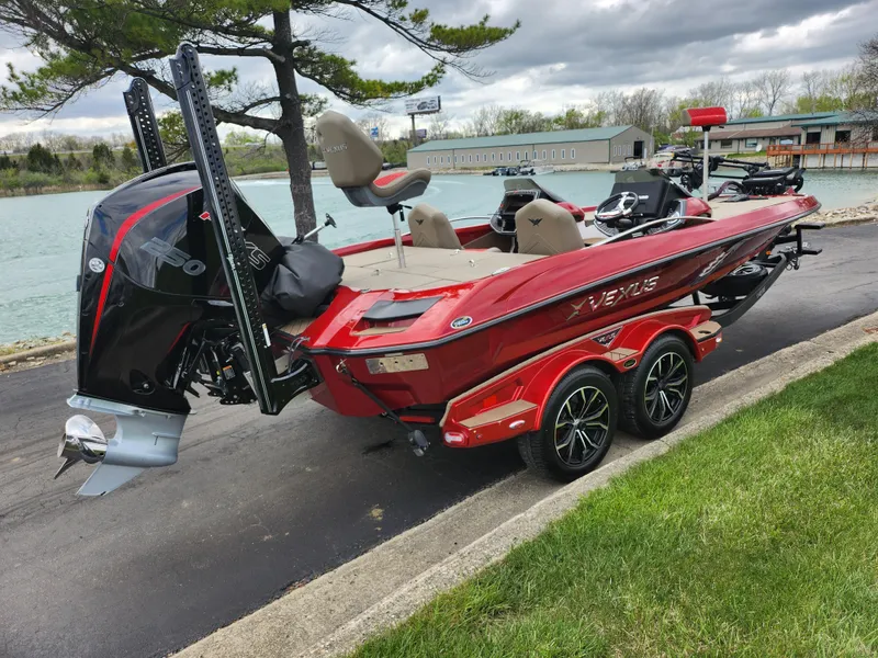 Slide: The Image of 2020 Vexus VX20 boat on trailer by a lake, featuring a powerful outboard motor. - 1