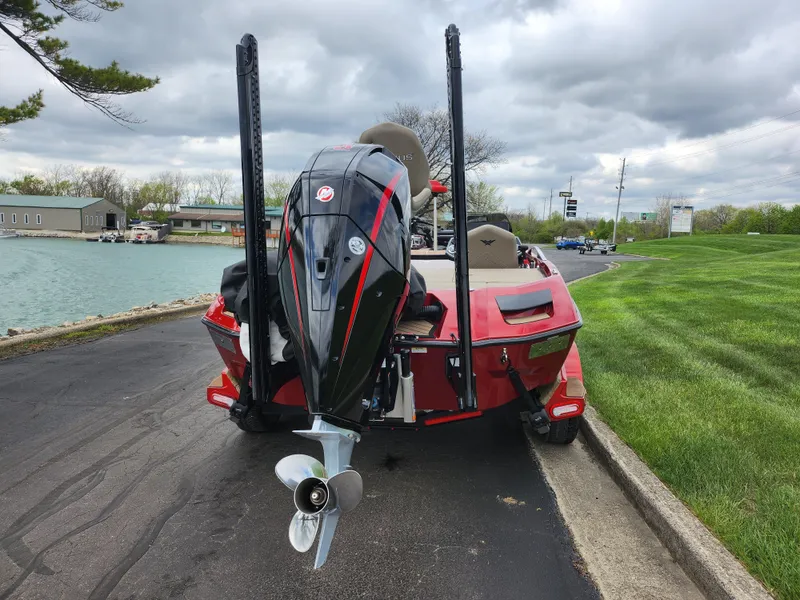 Slide: The Image of 2020 Vexus VX20 boat with powerful outboard motor, parked near a lake under cloudy skies. - 2