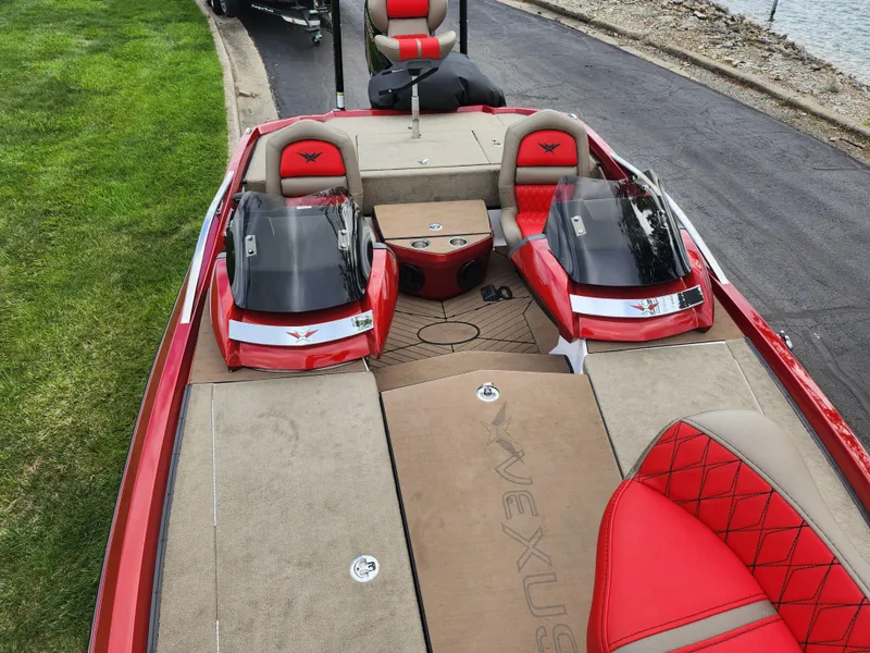 Slide: The Image of 2020 Vexus VX20 boat with red and beige interior, parked near a grassy area. - 21