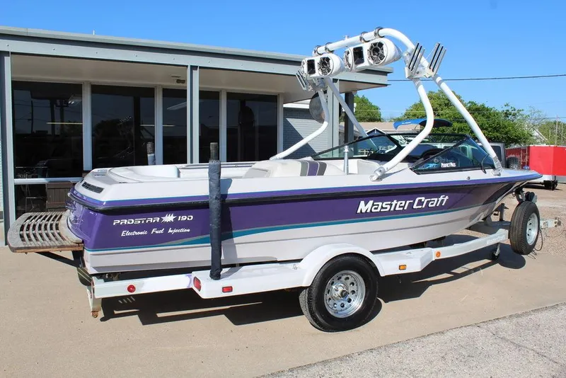 Slide: The Image of 1994 MasterCraft 190 Pro Star boat with purple accents parked on a trailer. - 4