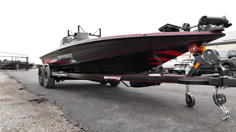 Slide: The Image of 2025 Phoenix 721 ZXL boat on trailer, black and red design, parked on asphalt. - 10