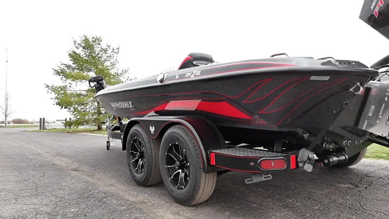 Slide: The Image of 2025 Phoenix 721 ZXL boat on trailer, black and red design, parked outdoors. - 22