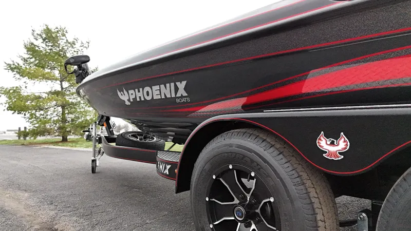 Slide: The Image of 2025 Phoenix 721 ZXL boat on trailer, black and red design, parked outdoors. - 23