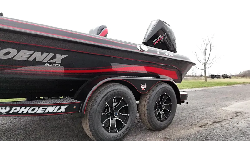 Slide: The Image of 2025 Phoenix 721 ZXL boat on trailer, black and red design, parked outdoors. - 24