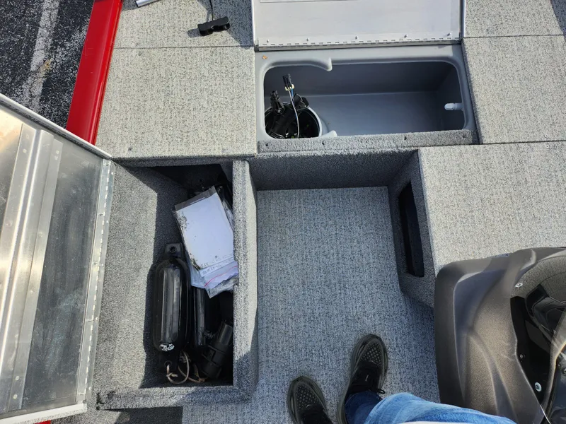 Slide: The Image of 2022 Tracker Pro 170 boat interior with storage compartments and gray carpet. - 16