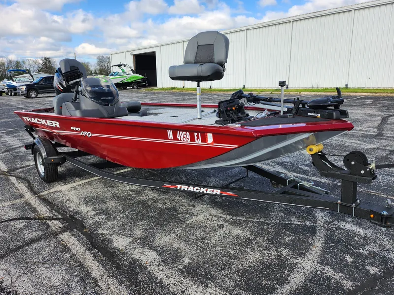 Slide: The Image of 2022 Tracker Pro 170 boat in red on a trailer, parked outdoors. - 5