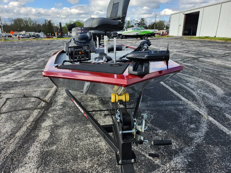 Slide: The Image of 2022 Tracker Pro 170 boat on trailer, parked outdoors, featuring red trim and motor. - 6