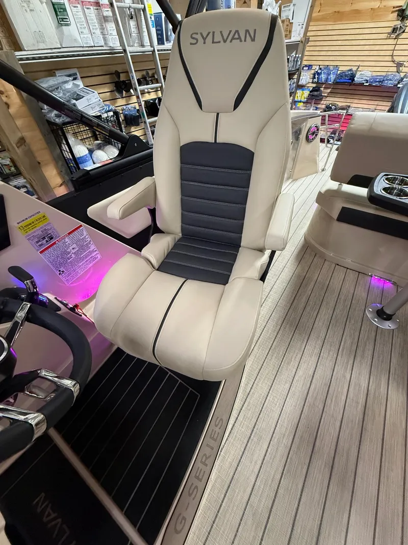Slide: The Image of 2025 Sylvan G-3 CLZ DH boat seat with beige and black design, in a showroom setting. - 28