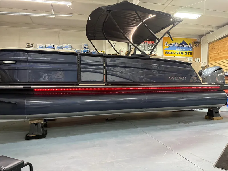 Slide: The Image of 2025 Sylvan G-3 CLZ DH pontoon boat in showroom with canopy and sleek design. - 3