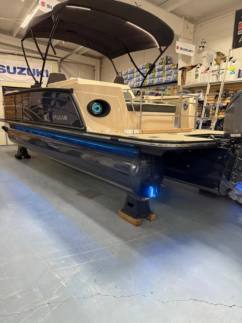 Slide: The Image of 2025 Sylvan G-3 CLZ DH pontoon boat in showroom with canopy and blue LED lights. - 31