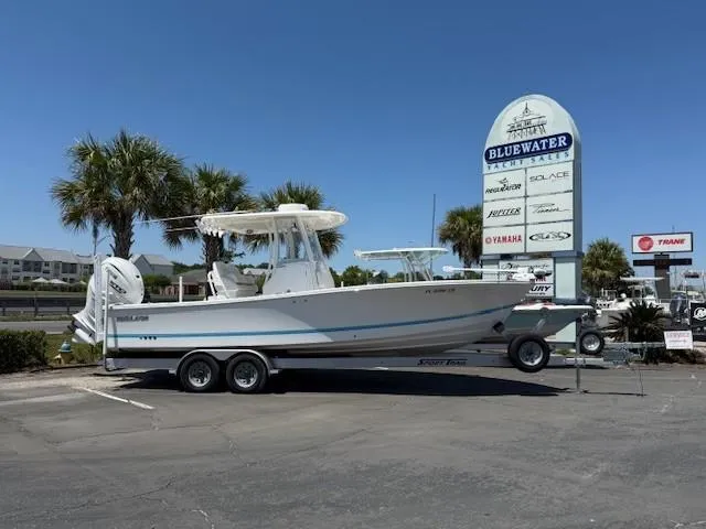 Slide: The Image of 2024 Regulator 26XO boat on trailer at Bluewater dealership, sunny day. - 0