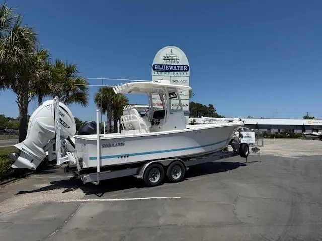 Slide: The Image of 2024 Regulator 26XO boat on trailer at Bluewater dealership, clear sky background. - 1
