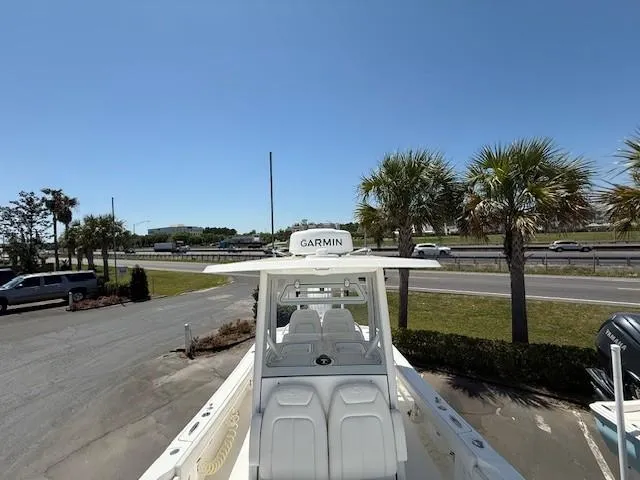 Slide: The Image of 2024 Regulator 26XO boat with Garmin equipment, parked near palm trees and a road. - 12