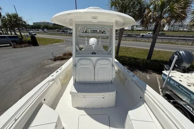 Slide: The Image of 2024 Regulator 26XO boat, white interior, center console, parked near palm trees. - 14