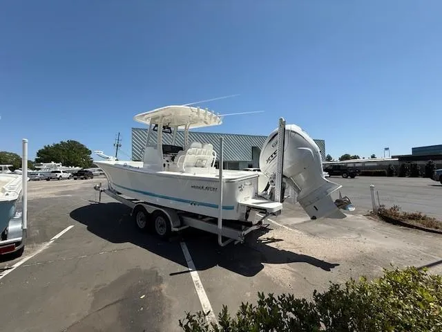 Slide: The Image of 2024 Regulator 26XO boat on trailer in parking lot, clear sky background. - 2