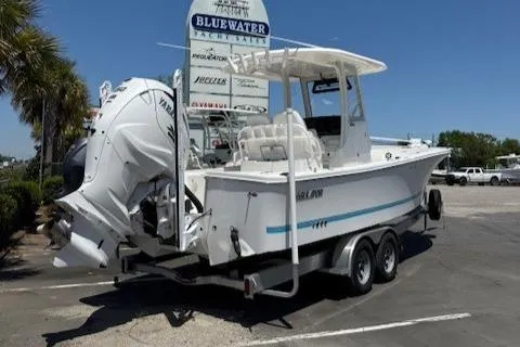 Slide: The Image of 2024 Regulator 26XO boat on trailer at Bluewater dealership, featuring powerful outboard engine. - 4