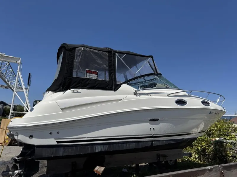 Slide: The Image of 2006 Sea Ray Sundancer boat with black canopy, displayed for sale under clear blue sky. - 1