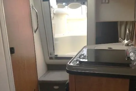 Slide: The Image of Interior view of 2006 Sea Ray Sundancer yacht, featuring compact kitchen and cabin entry. - 16