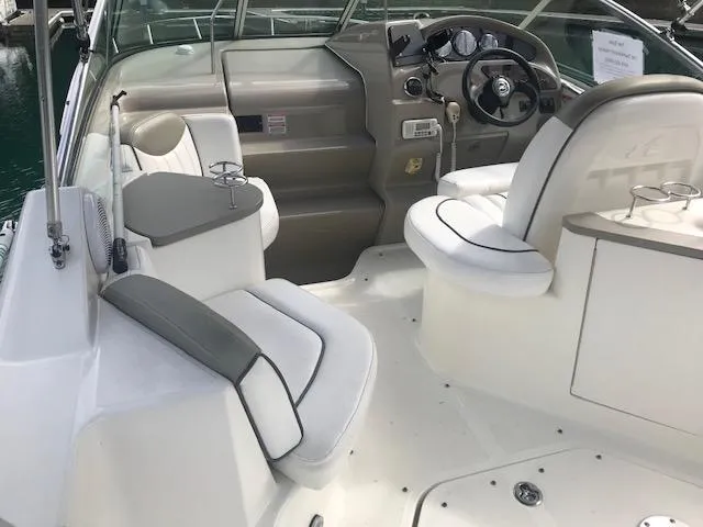 Slide: The Image of 2006 Sea Ray Sundancer boat interior with white seating and steering console. - 7